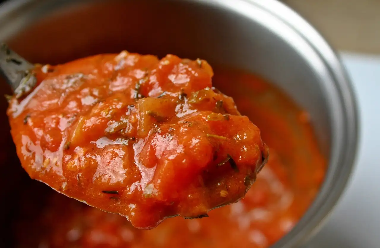 Como o cozimento lento intensifica o sabor do molho de tomate?